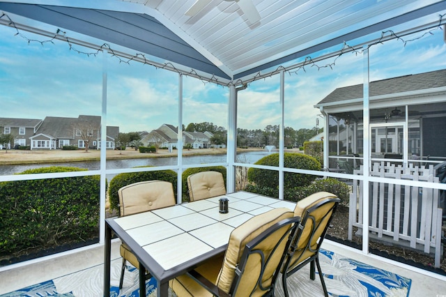 sunroom / solarium with lofted ceiling and a water view