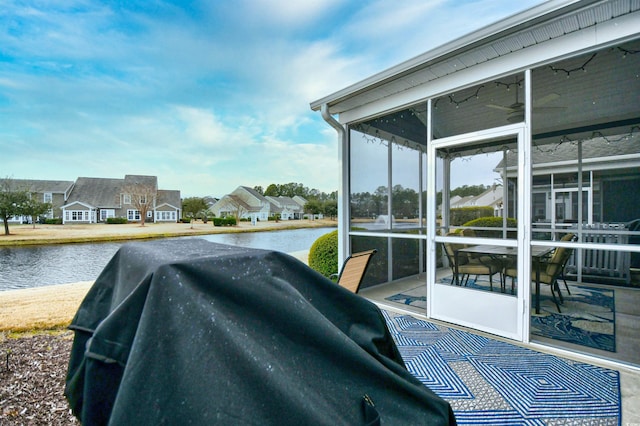 view of patio with a water view and a sunroom