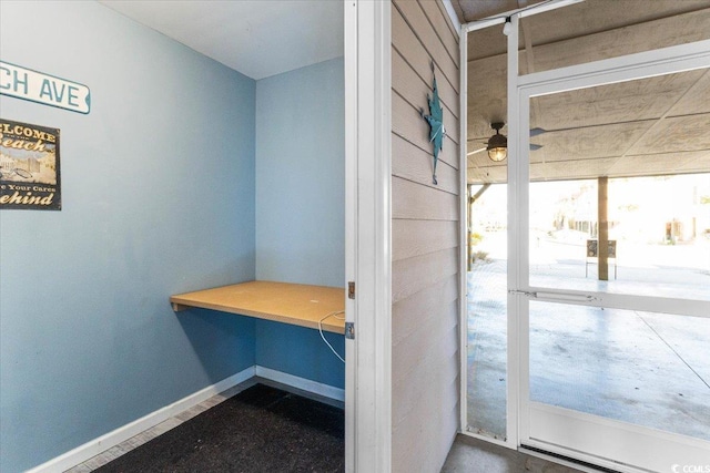 interior space with built in desk and ceiling fan