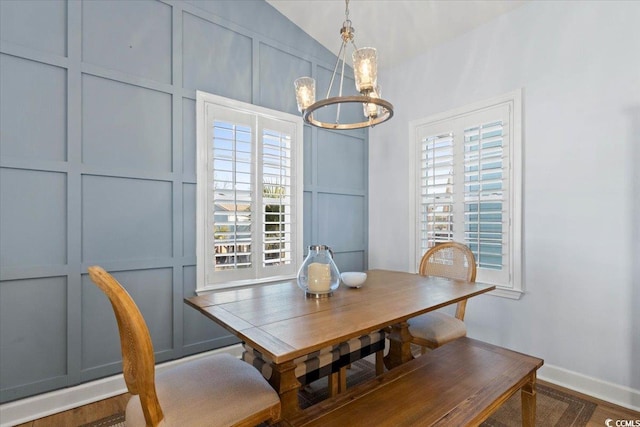 dining room with vaulted ceiling and a chandelier