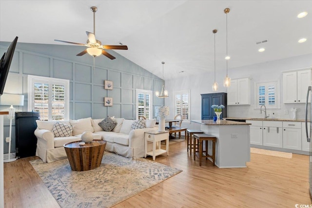 living room with light hardwood / wood-style flooring, sink, and a wealth of natural light