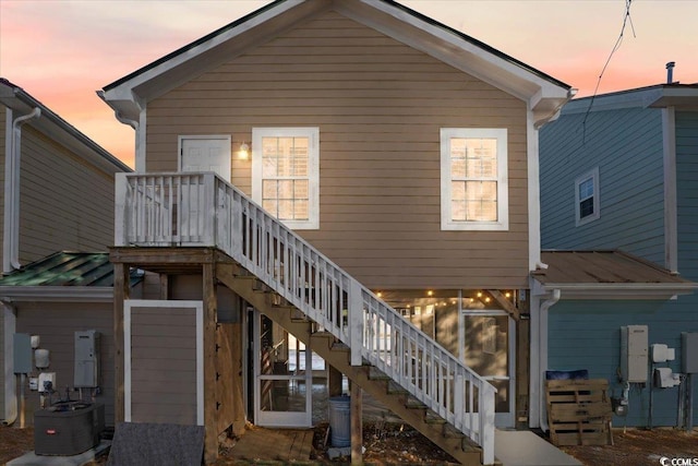 back house at dusk with central air condition unit