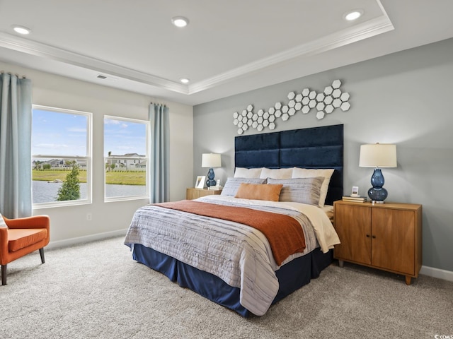 carpeted bedroom featuring crown molding and a tray ceiling