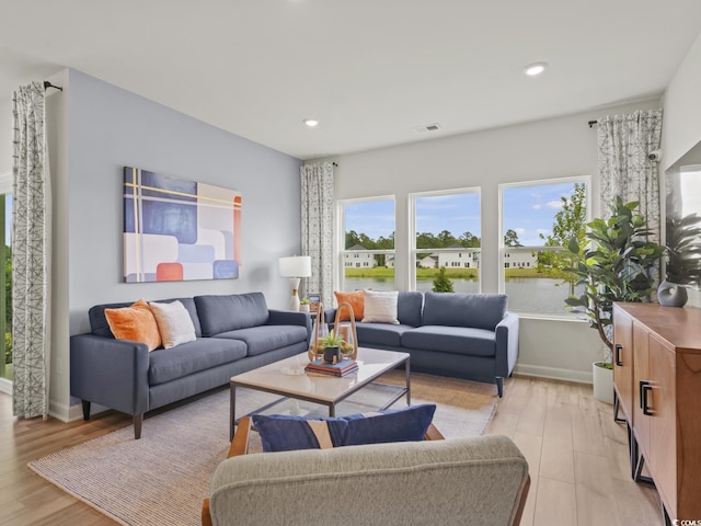 living room featuring a water view and light wood-type flooring