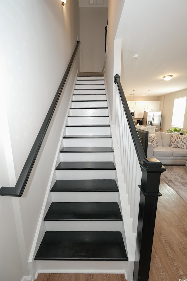 staircase featuring wood-type flooring