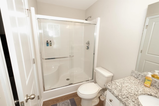 bathroom featuring vanity, hardwood / wood-style floors, toilet, and walk in shower