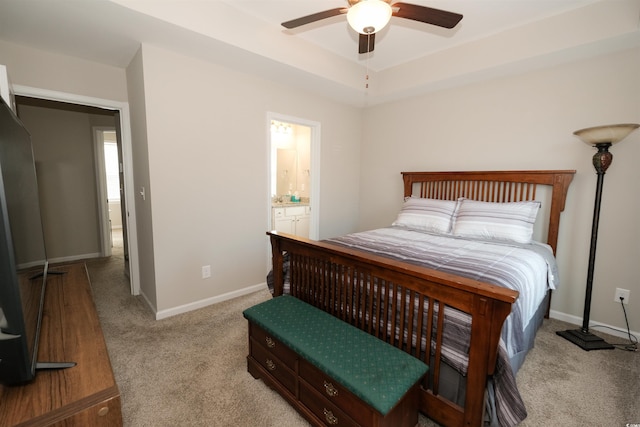 bedroom featuring a raised ceiling, light colored carpet, and ceiling fan