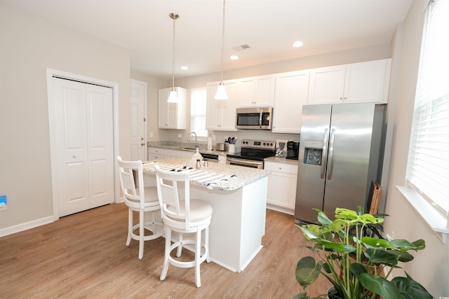 kitchen featuring pendant lighting, appliances with stainless steel finishes, and white cabinets