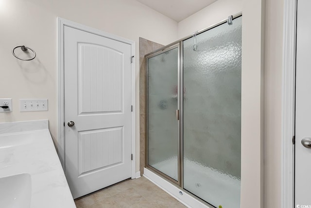 bathroom featuring vanity, a shower with shower door, and tile patterned flooring