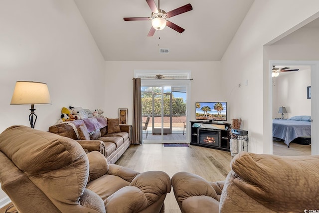 living room with high vaulted ceiling, light hardwood / wood-style floors, and ceiling fan