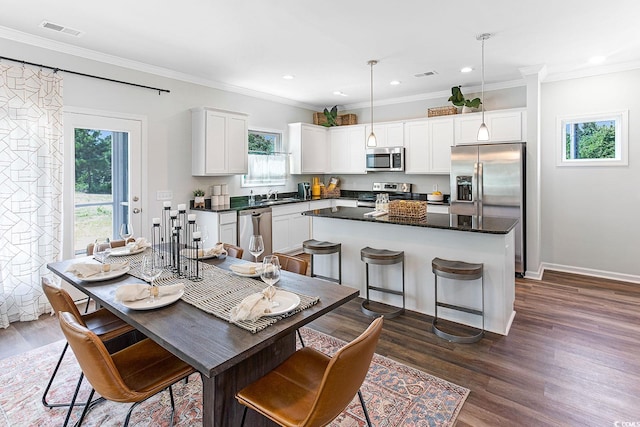 dining space with sink, crown molding, and dark hardwood / wood-style floors