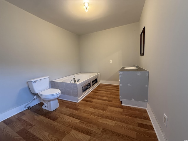 bathroom with vanity, toilet, hardwood / wood-style floors, and a washtub