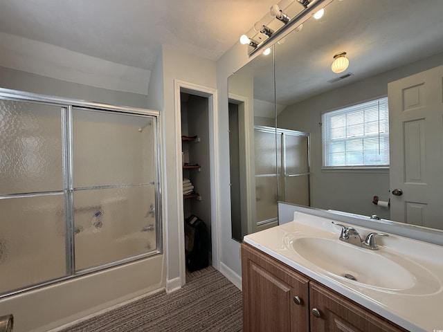 bathroom with vanity and bath / shower combo with glass door