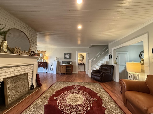 living room with hardwood / wood-style flooring, ornamental molding, wood ceiling, and a fireplace