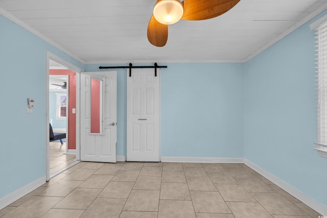 unfurnished room featuring crown molding, ceiling fan, a barn door, and light tile patterned floors