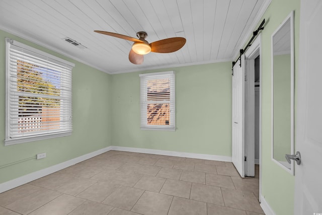 unfurnished room with crown molding, ceiling fan, light tile patterned flooring, wooden ceiling, and a barn door