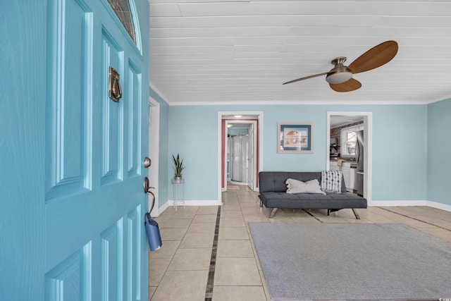 entrance foyer featuring ceiling fan, ornamental molding, and light tile patterned floors