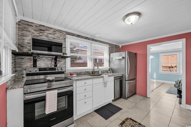 kitchen featuring sink, white cabinetry, ornamental molding, appliances with stainless steel finishes, and light stone countertops