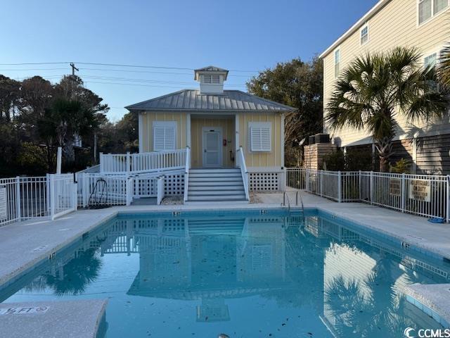 community pool featuring an outdoor structure and fence