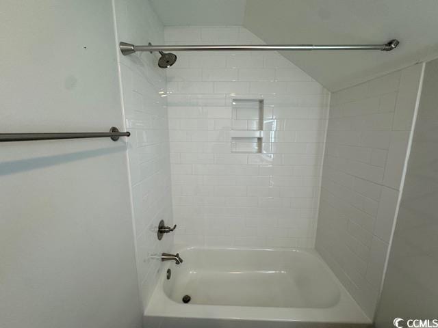 bathroom featuring tiled shower / bath and lofted ceiling