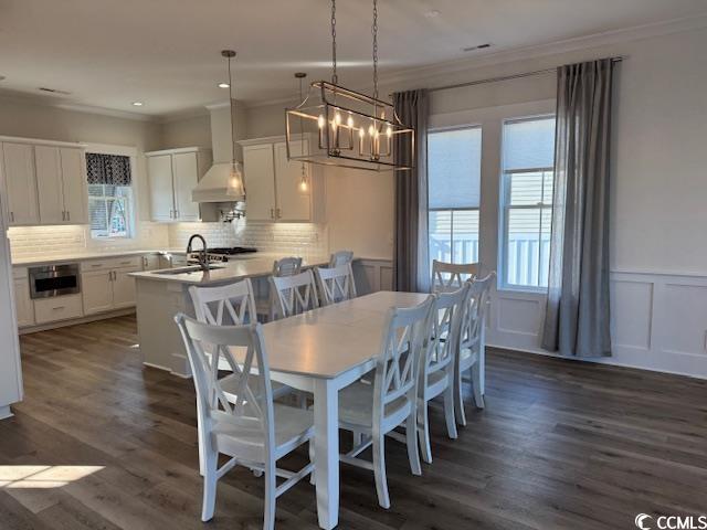 dining area with dark hardwood / wood-style flooring, sink, and crown molding