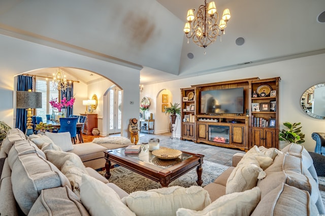 living room featuring crown molding, a notable chandelier, and high vaulted ceiling