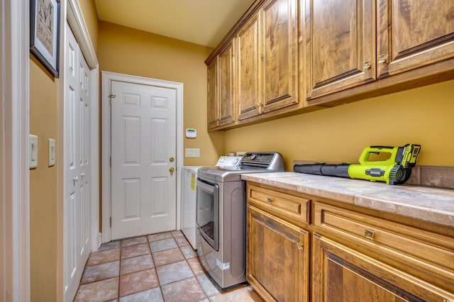 clothes washing area featuring cabinets and washing machine and dryer