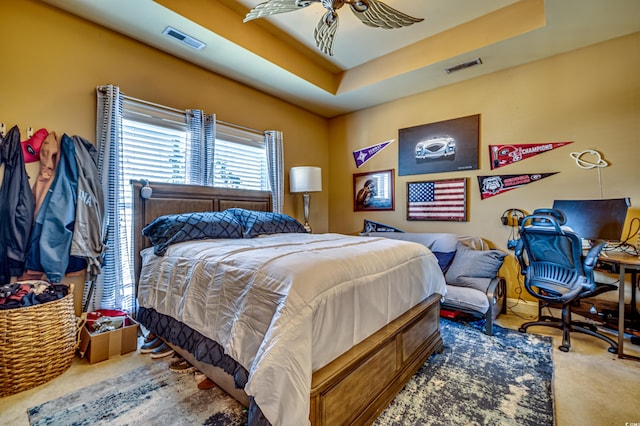 bedroom featuring carpet floors and a tray ceiling