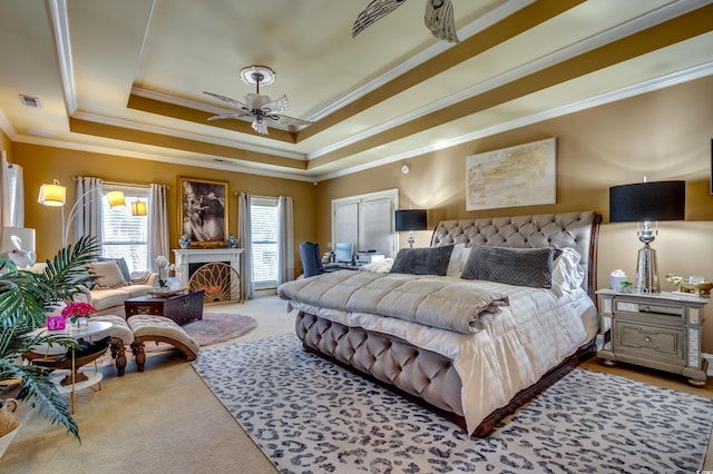 bedroom with ceiling fan, ornamental molding, a raised ceiling, and light carpet