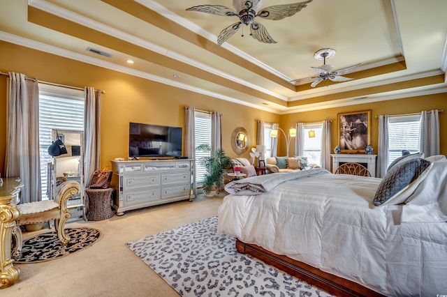 carpeted bedroom featuring a raised ceiling, ornamental molding, and multiple windows