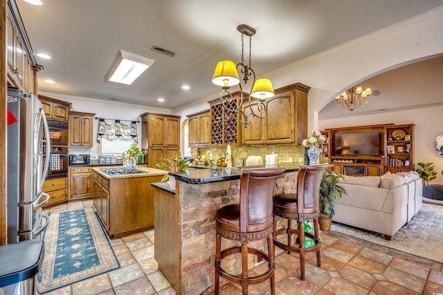 kitchen featuring a kitchen breakfast bar, a kitchen island, pendant lighting, stainless steel appliances, and backsplash