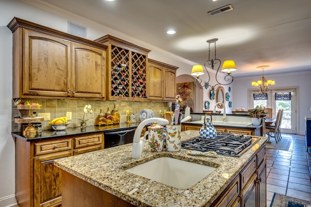 kitchen featuring decorative light fixtures, dishwasher, sink, stainless steel gas cooktop, and a center island with sink