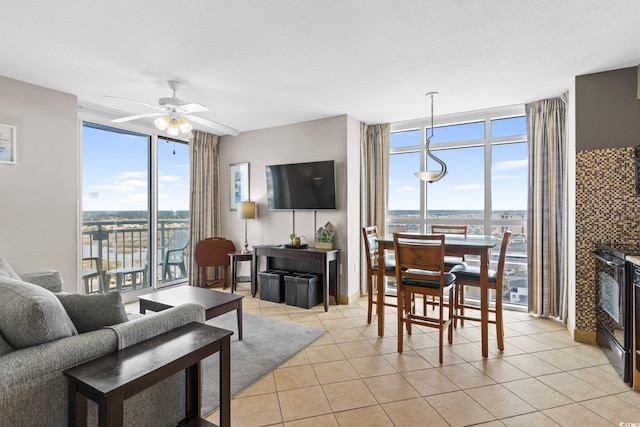 living room featuring light tile patterned floors, floor to ceiling windows, and ceiling fan