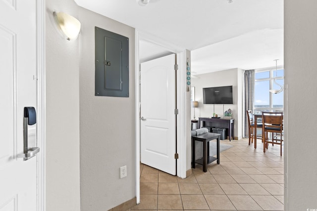 corridor featuring floor to ceiling windows, light tile patterned floors, and electric panel