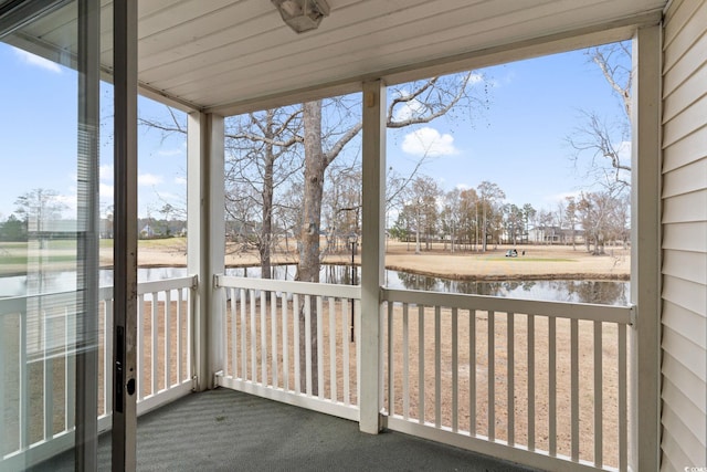 unfurnished sunroom featuring a water view