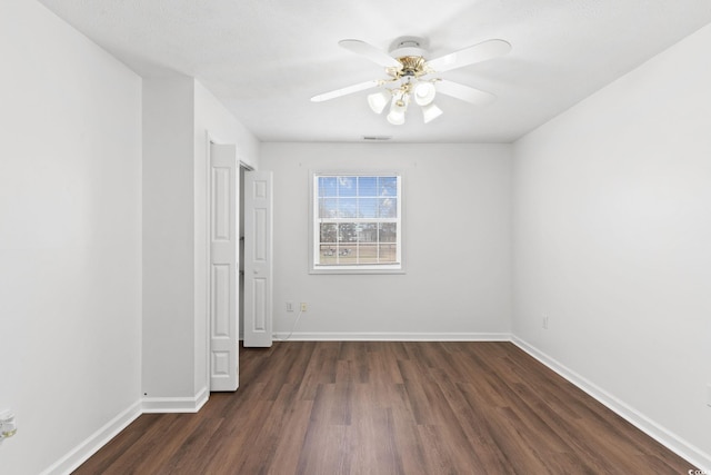 unfurnished room featuring dark wood-type flooring and ceiling fan