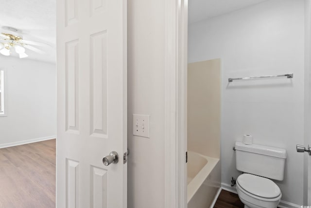 bathroom featuring a bathing tub, wood-type flooring, and toilet