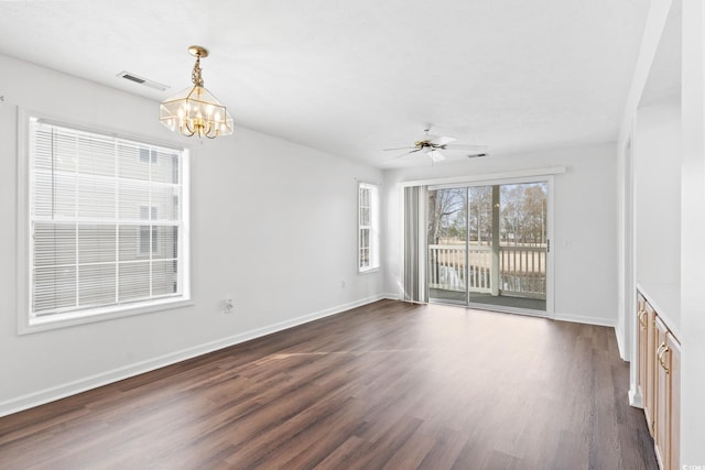 unfurnished living room featuring dark hardwood / wood-style floors and ceiling fan with notable chandelier