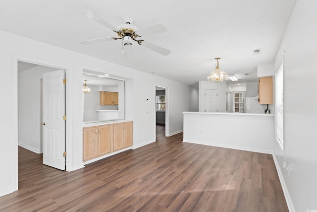 unfurnished living room with dark hardwood / wood-style floors and ceiling fan with notable chandelier