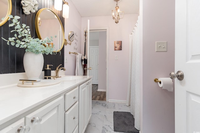 full bath with baseboards, marble finish floor, and vanity