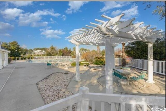 view of patio with a fenced backyard, a community pool, and a pergola