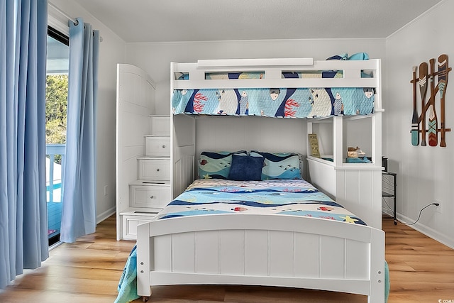 bedroom with crown molding and light hardwood / wood-style floors