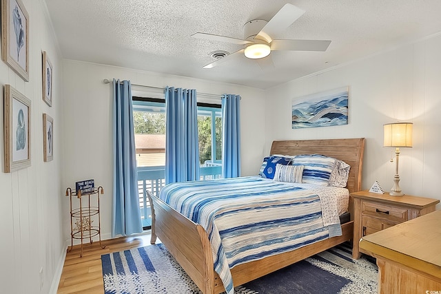 bedroom with ceiling fan, a textured ceiling, and light hardwood / wood-style flooring