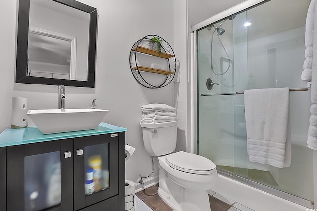 bathroom featuring vanity, a shower with door, and toilet