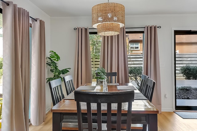 dining room with ornamental molding, plenty of natural light, and light wood-type flooring