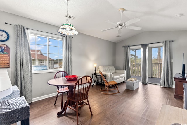 dining space with dark wood-type flooring, ceiling fan, lofted ceiling, and a textured ceiling