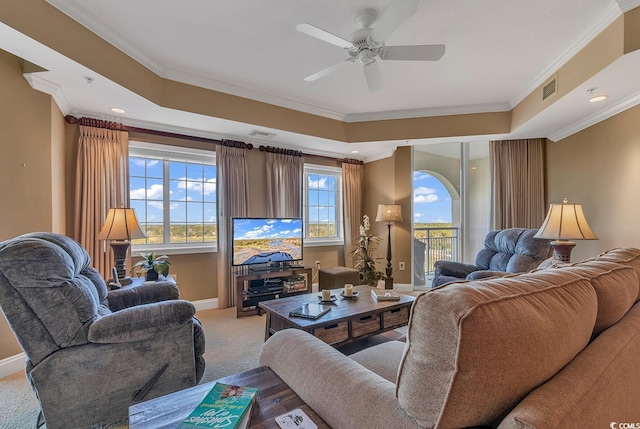 carpeted living area featuring a ceiling fan, baseboards, visible vents, and ornamental molding