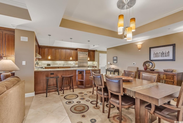 dining space with crown molding and a raised ceiling