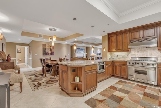 kitchen with crown molding, luxury range, open floor plan, under cabinet range hood, and a tray ceiling