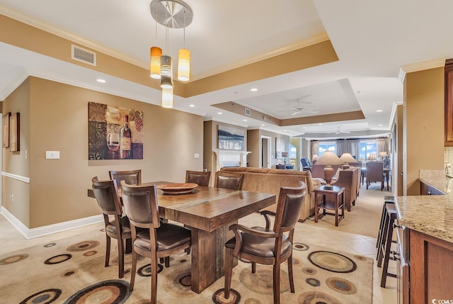 dining area featuring a ceiling fan, visible vents, light tile patterned floors, a raised ceiling, and ornamental molding